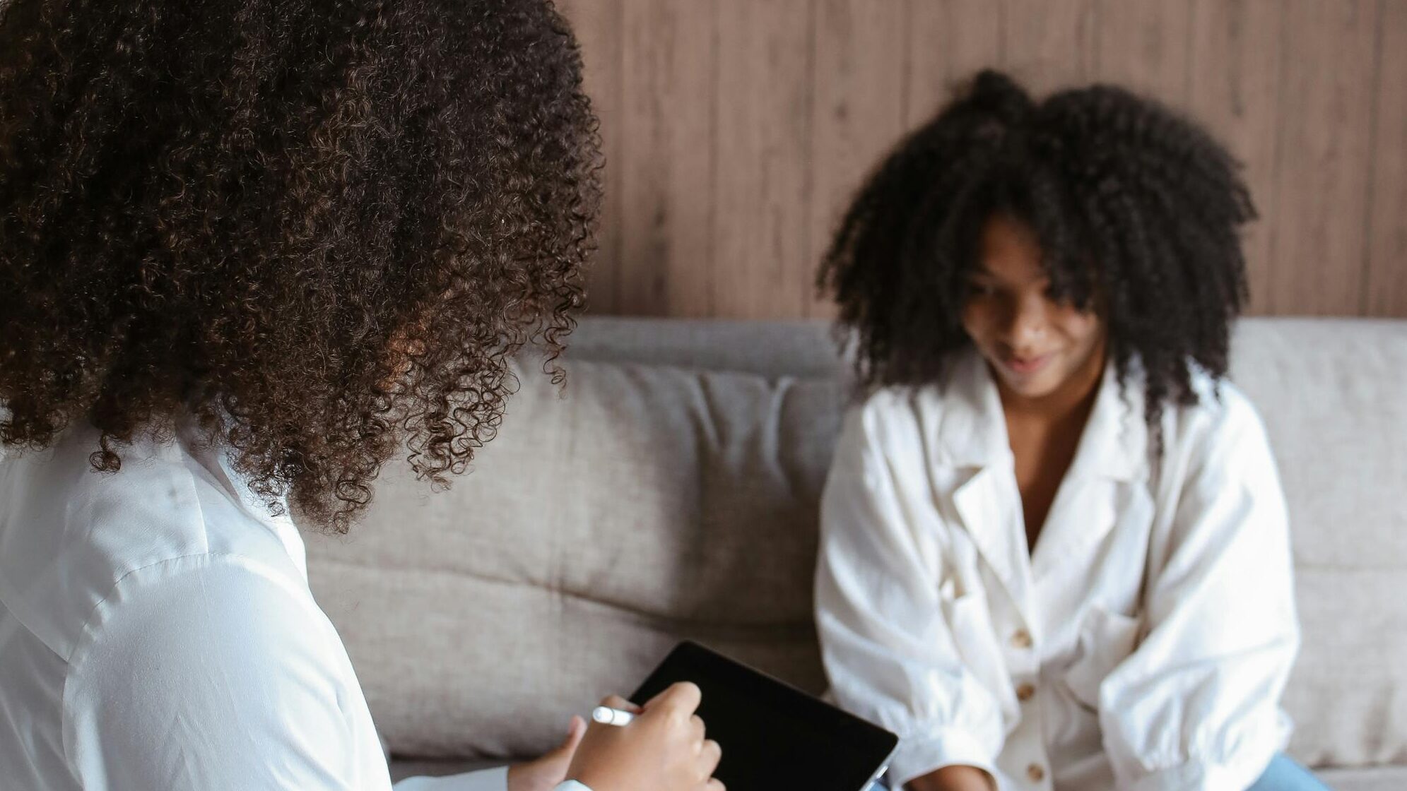 Two women in a psychotherapy session discussing mental health issues.