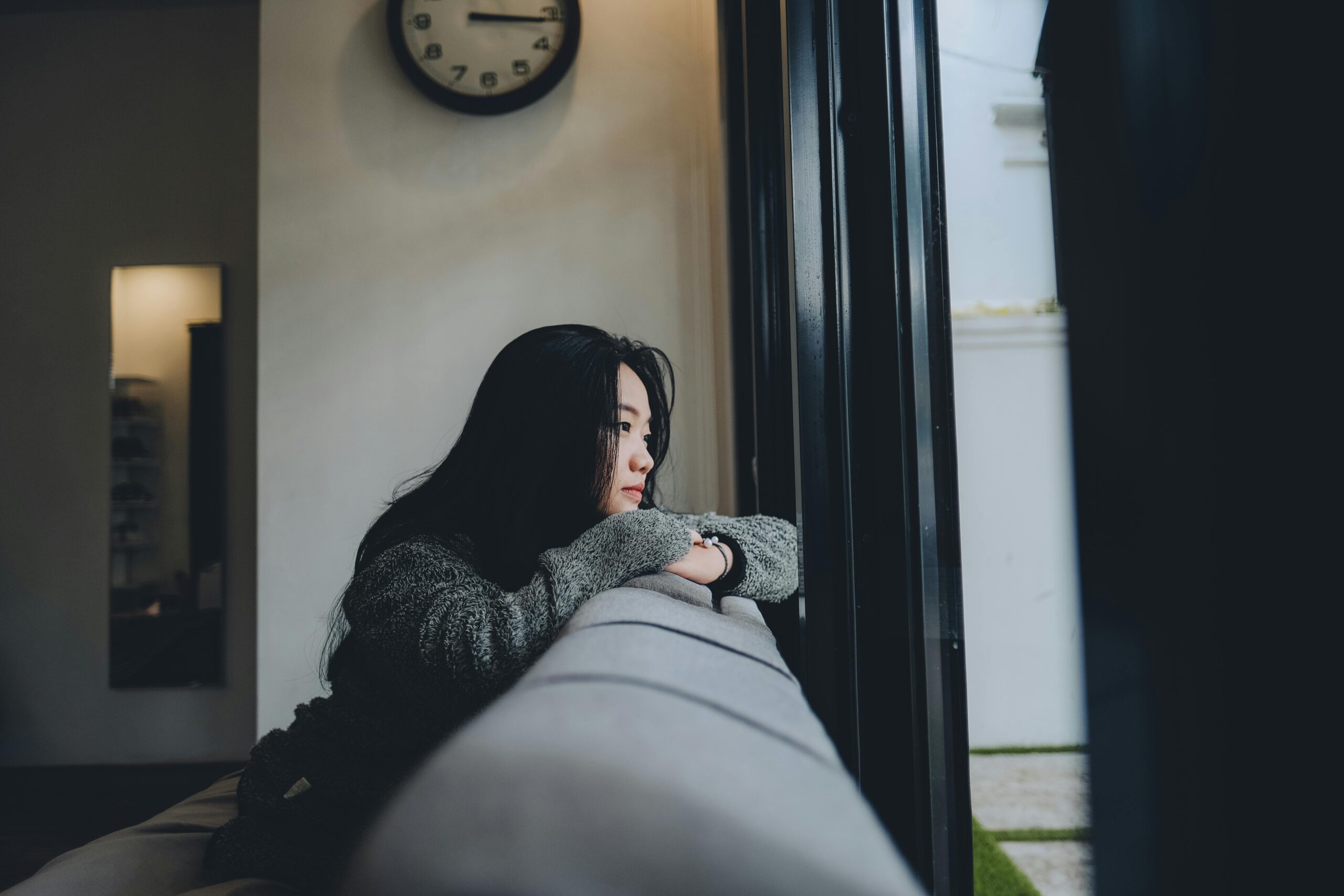 Person gazing out a window while reflecting on their thoughts and emotions.